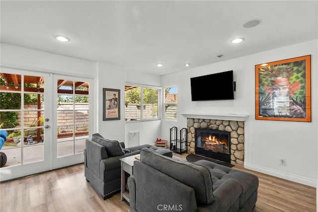 19777 Azure Field Dr, Newhall, CA 91321 - living room with wood finished floors, french doors, a stone fireplace, baseboards, and recessed lighting
