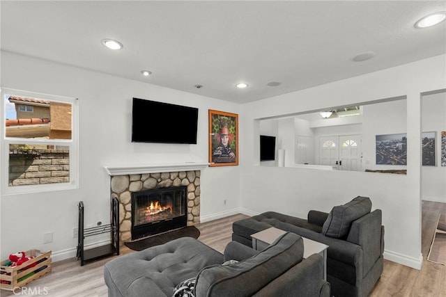 19777 Azure Field Dr, Newhall, CA 91321 - living room featuring a stone fireplace, wood finished floors, recessed lighting, and baseboards