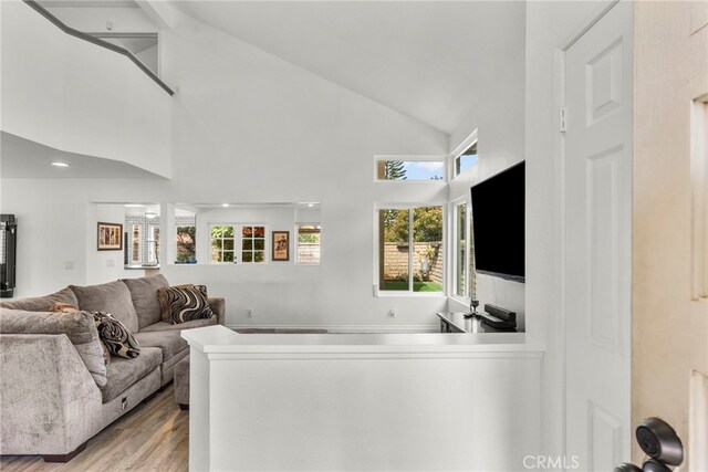 19777 Azure Field Dr, Newhall, CA 91321 - living room featuring wood finished floors, high vaulted ceiling, and plenty of natural light