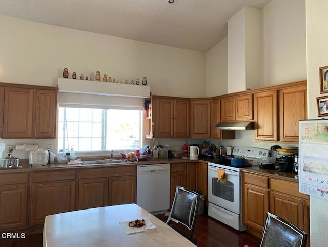 10424 Santa Fe Fire Rd, Lucerne Valley, CA 92356 - kitchen with white appliances, under cabinet range hood, a sink, brown cabinets, and high vaulted ceiling