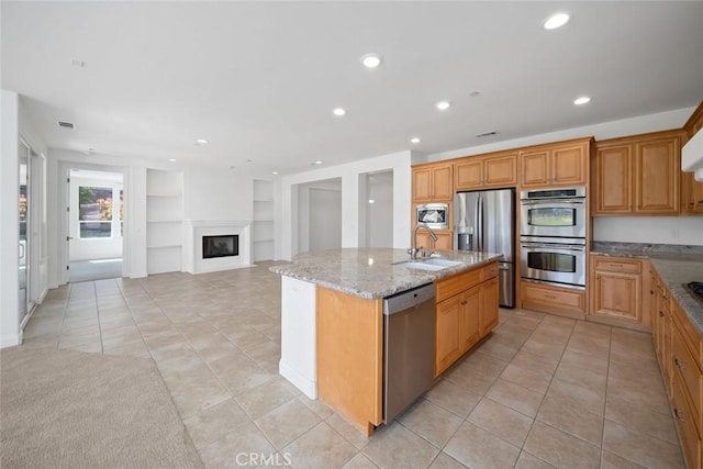 1824 Nathan Way, Nipomo, CA 93444 - kitchen with stainless steel appliances, built in shelves, a center island with sink, light tile patterned floors, and light stone countertops