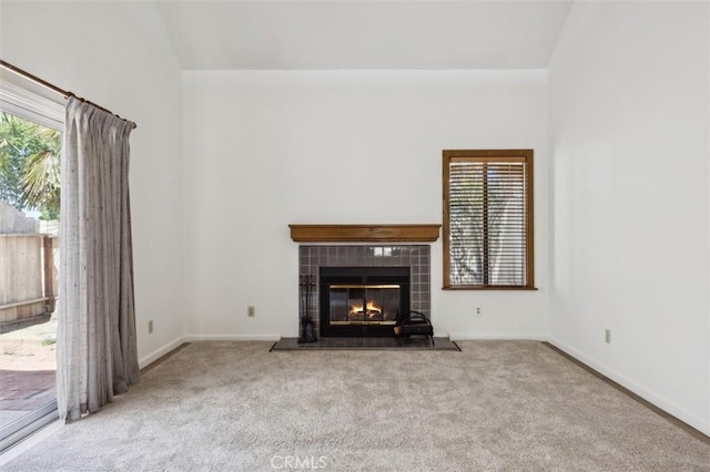 10710 El Camino Real Unit 17, Atascadero, CA 93422 - unfurnished living room featuring carpet, a tile fireplace, plenty of natural light, and lofted ceiling