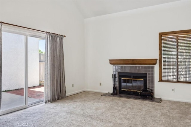 10710 El Camino Real Unit 17, Atascadero, CA 93422 - unfurnished living room featuring carpet, a tile fireplace, high vaulted ceiling, and baseboards