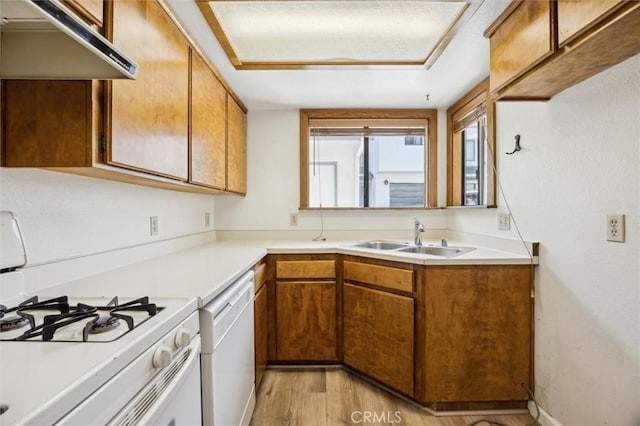 10710 El Camino Real Unit 17, Atascadero, CA 93422 - kitchen with a sink, white appliances, under cabinet range hood, brown cabinets, and light wood-style floors