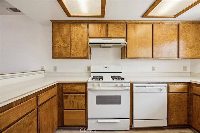 10710 El Camino Real Unit 17, Atascadero, CA 93422 - kitchen featuring white appliances, under cabinet range hood, brown cabinetry, and light countertops
