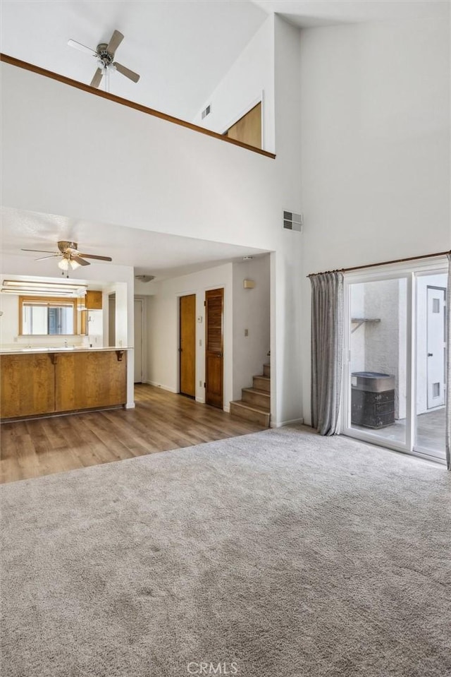10710 El Camino Real Unit 17, Atascadero, CA 93422 - unfurnished living room featuring high vaulted ceiling, ceiling fan, carpet floors, and stairway