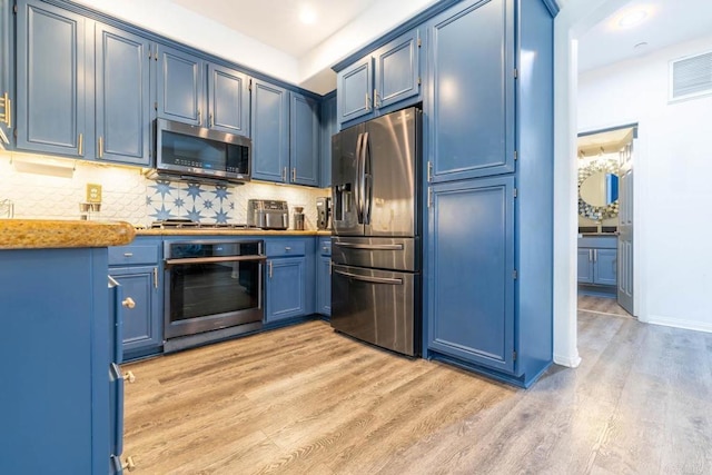 2772 Piantino Cir, San Diego, CA 92108 - kitchen with appliances with stainless steel finishes, blue cabinetry, light wood-style flooring, decorative backsplash, and baseboards
