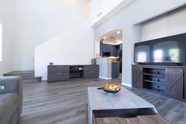2772 Piantino Cir, San Diego, CA 92108 - living room featuring arched walkways, wood finished floors, a towering ceiling, and baseboards