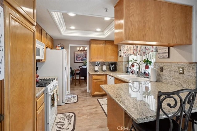 29159 Palm View Ln, Highland, CA 92346 - kitchen with white appliances, a sink, a peninsula, a raised ceiling, and a kitchen bar