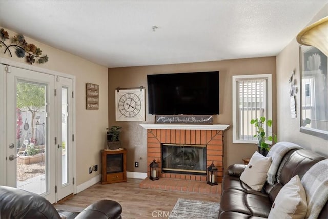 29159 Palm View Ln, Highland, CA 92346 - living area with wood finished floors, plenty of natural light, a fireplace, and baseboards