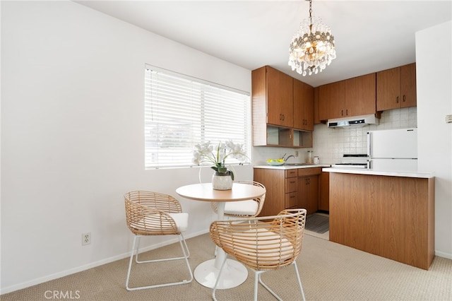 538 Palisades Ave, Santa Monica, CA 90402 - kitchen featuring under cabinet range hood, freestanding refrigerator, light countertops, backsplash, and a chandelier