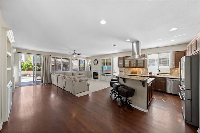23650 Kathryn St, Murrieta, CA 92562 - kitchen with island range hood, stainless steel appliances, a breakfast bar area, open floor plan, and backsplash