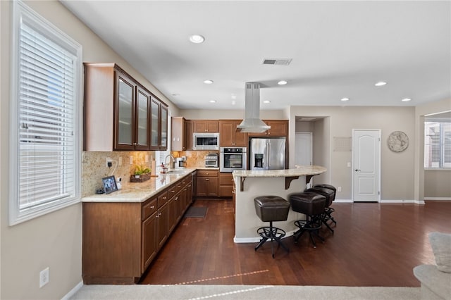 23650 Kathryn St, Murrieta, CA 92562 - kitchen with stainless steel appliances, a sink, island exhaust hood, a breakfast bar, and dark wood-type flooring