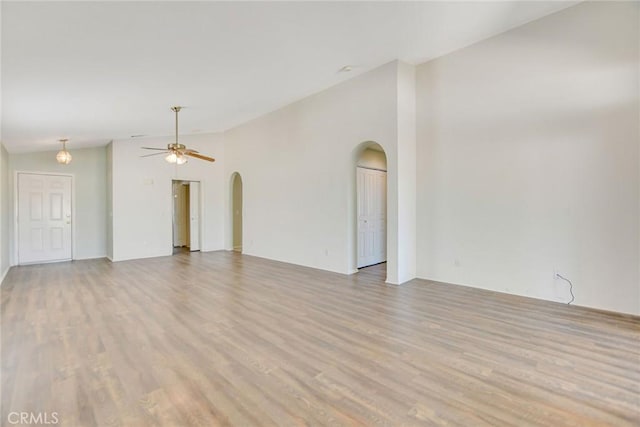 11241 Pleasant Hills Dr, Apple Valley, CA 92308 - unfurnished living room featuring arched walkways, lofted ceiling, light wood-style floors, and a ceiling fan