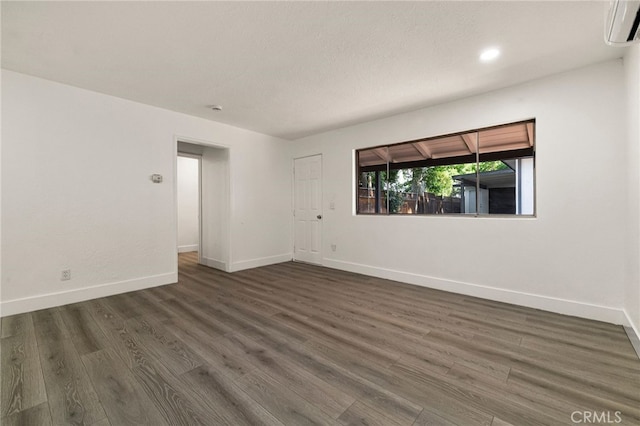 178 E Washington Ave, Chico, CA 95926 - empty room featuring an AC wall unit, dark wood-type flooring, baseboards, and recessed lighting