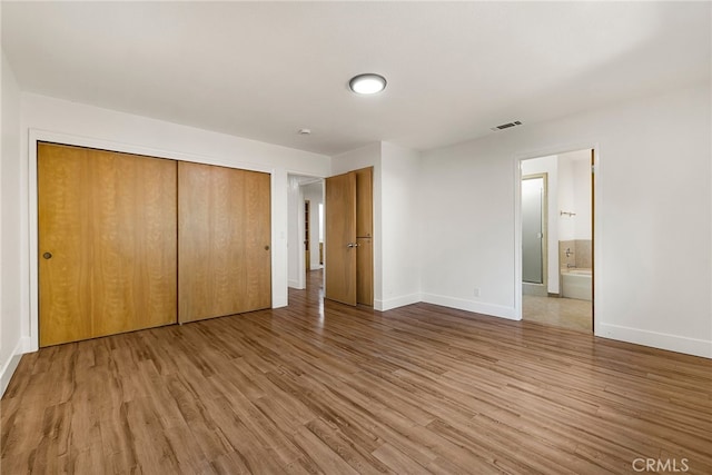 178 E Washington Ave, Chico, CA 95926 - unfurnished bedroom with baseboards, wood finished floors, a closet, and connected bathroom
