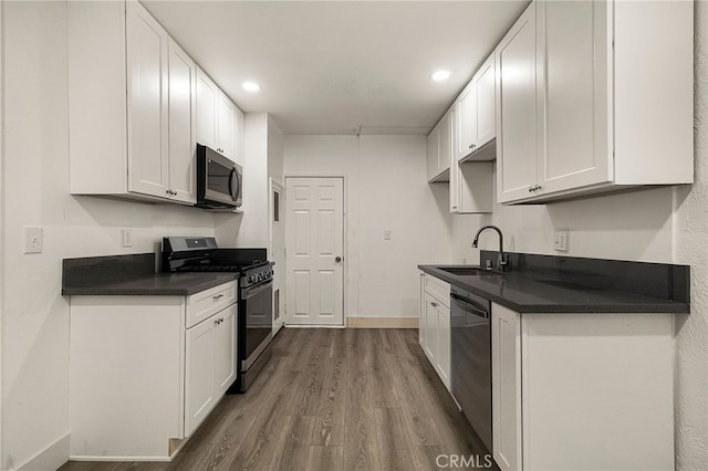 178 E Washington Ave, Chico, CA 95926 - kitchen featuring appliances with stainless steel finishes, a sink, dark wood-style floors, white cabinetry, and dark countertops