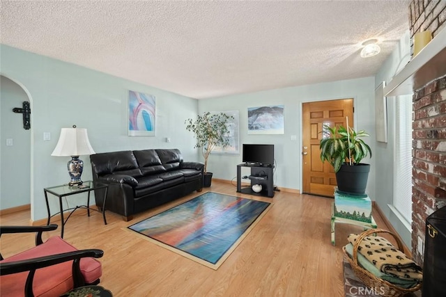 243 N 11th St, Grover Beach, CA 93433 - living room featuring a textured ceiling, wood finished floors, and arched walkways