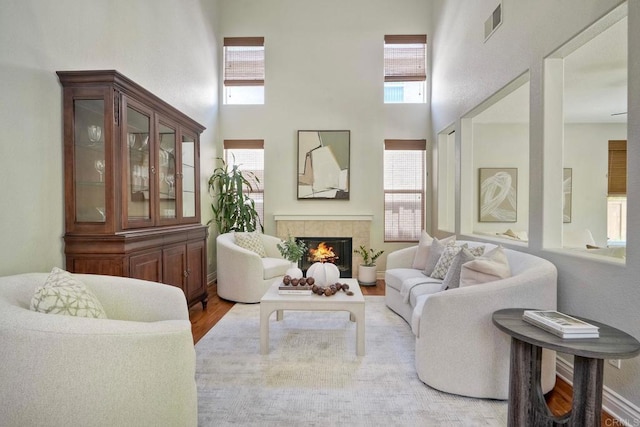 11983 Mountain Pass Rd, San Diego, CA 92128 - living room featuring a high ceiling, healthy amount of natural light, a fireplace, and light wood-style flooring