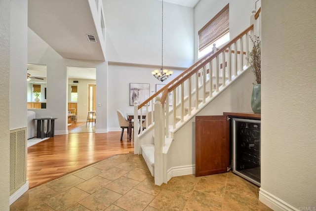 11983 Mountain Pass Rd, San Diego, CA 92128 - entryway featuring wine cooler, stairs, a chandelier, stone tile flooring, and baseboards