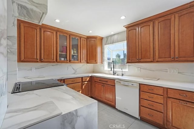 15330 Hart St, Van Nuys, CA 91406 - kitchen with white dishwasher, a sink, glass insert cabinets, light stone countertops, and brown cabinetry