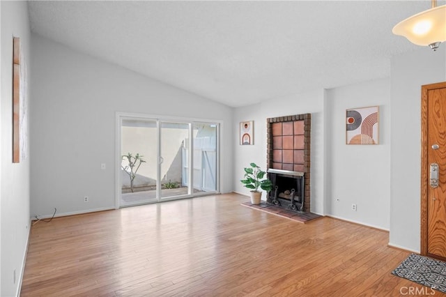 22792 La Quinta Dr, Mission Viejo, CA 92691 - living room featuring wood finished floors, a fireplace, vaulted ceiling, and baseboards
