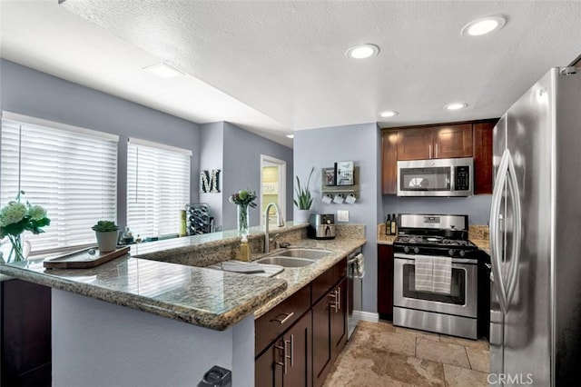 6223 Newhaven Ct, Yorba Linda, CA 92887 - kitchen with appliances with stainless steel finishes, a sink, a peninsula, light stone finish flooring, and recessed lighting