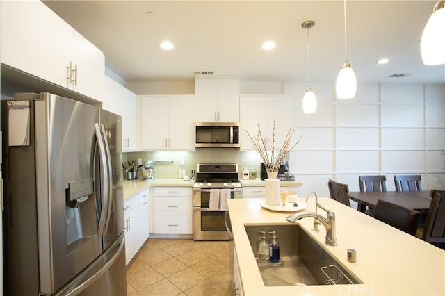 16 Fenix St, Rancho Mission Viejo, CA 92694 - kitchen with appliances with stainless steel finishes, a sink, light countertops, tasteful backsplash, and hanging light fixtures