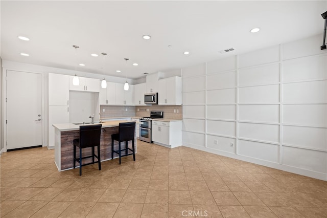 16 Fenix St, Rancho Mission Viejo, CA 92694 - kitchen with appliances with stainless steel finishes, recessed lighting, light countertops, a kitchen island with sink, and tasteful backsplash