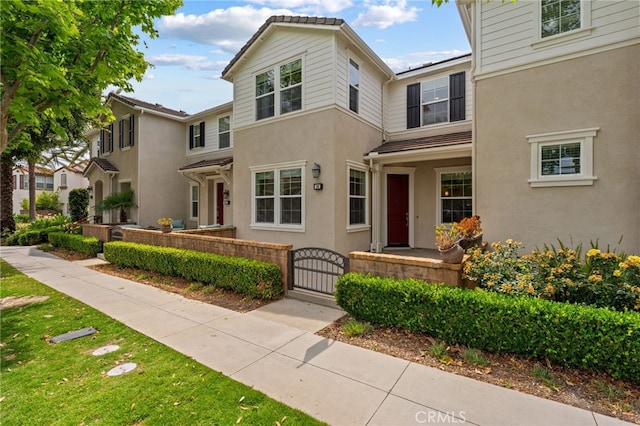 16 Fenix St, Rancho Mission Viejo, CA 92694 - view of front of home featuring stucco siding, a gate, and a fenced front yard