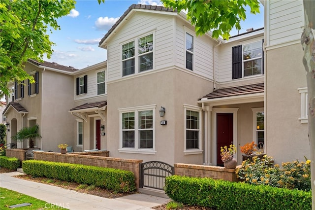 16 Fenix St, Rancho Mission Viejo, CA 92694 - townhome / multi-family property featuring a gate, a fenced front yard, and stucco siding