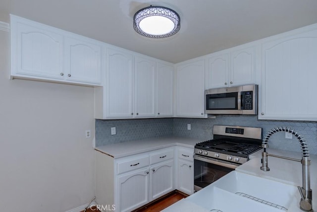 19134 Alamo Ln Unit 162, Yorba Linda, CA 92886 - kitchen with appliances with stainless steel finishes, backsplash, white cabinetry, and light countertops