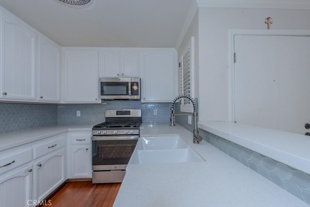 19134 Alamo Ln Unit 162, Yorba Linda, CA 92886 - kitchen with appliances with stainless steel finishes, a sink, tasteful backsplash, crown molding, and white cabinetry