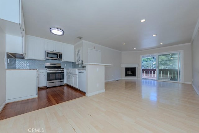 19134 Alamo Ln Unit 162, Yorba Linda, CA 92886 - kitchen with stainless steel appliances, open floor plan, a peninsula, crown molding, and white cabinetry
