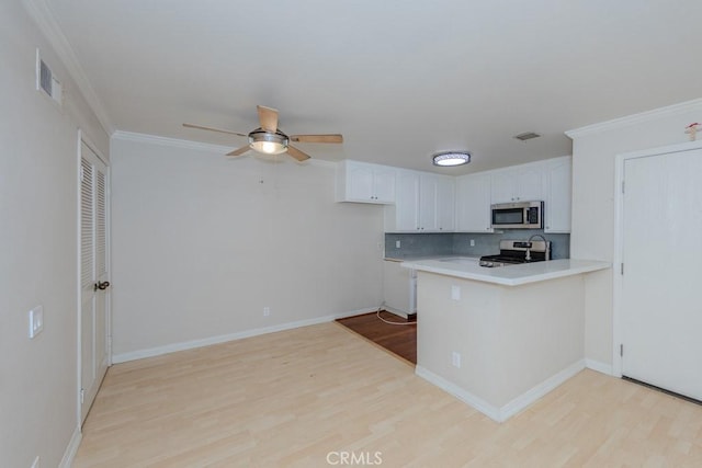 19134 Alamo Ln Unit 162, Yorba Linda, CA 92886 - kitchen featuring appliances with stainless steel finishes, light wood-style flooring, a peninsula, white cabinetry, and ornamental molding