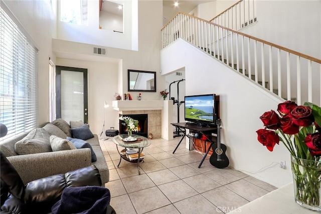 3738 Springmount St, Riverside, CA 92501 - tiled living room with a high ceiling, stairs, healthy amount of natural light, and a fireplace