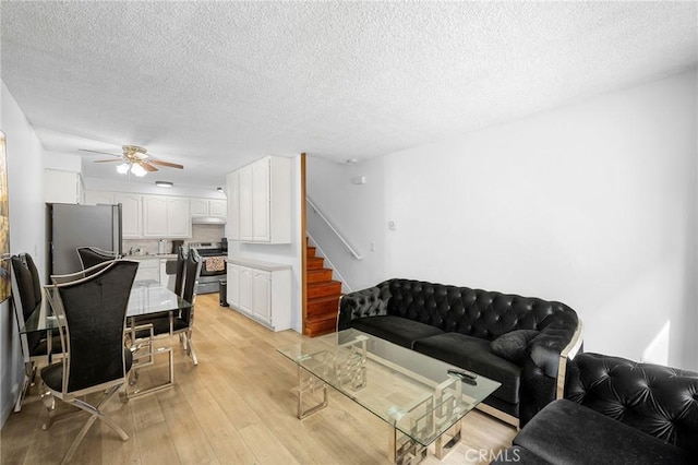 11025 Kittridge St Unit 128, North Hollywood, CA 91606 - living area with a ceiling fan, a textured ceiling, light wood-style floors, and stairs