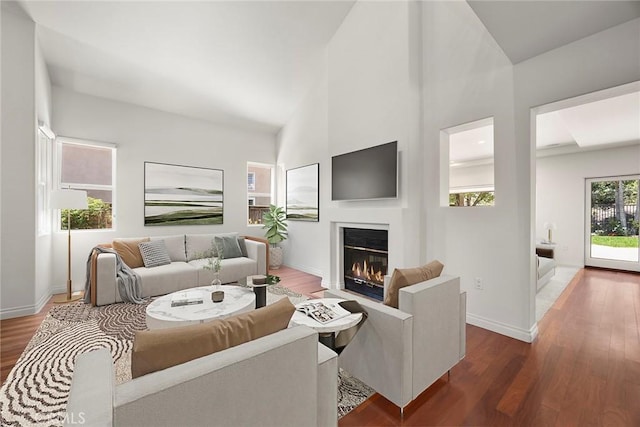 21 Mykonos, Laguna Niguel, CA 92677 - living area with a glass covered fireplace, baseboards, wood finished floors, and high vaulted ceiling
