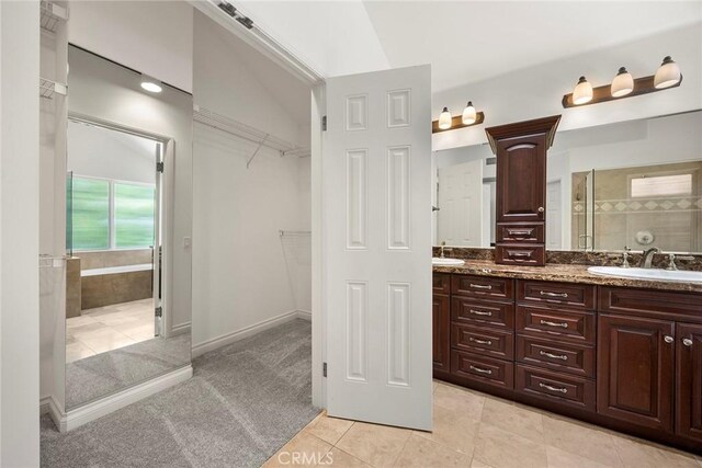 21 Mykonos, Laguna Niguel, CA 92677 - bathroom with double vanity, tiled shower, a spacious closet, and tile patterned floors