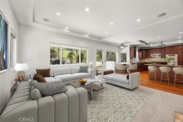 21 Mykonos, Laguna Niguel, CA 92677 - living room with a raised ceiling, recessed lighting, light colored carpet, a ceiling fan, and light wood finished floors