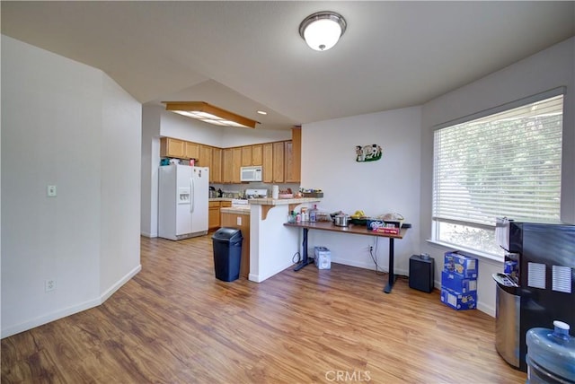 9024 Cascada Rd, Atascadero, CA 93422 - kitchen with white appliances, a peninsula, light wood finished floors, and a breakfast bar
