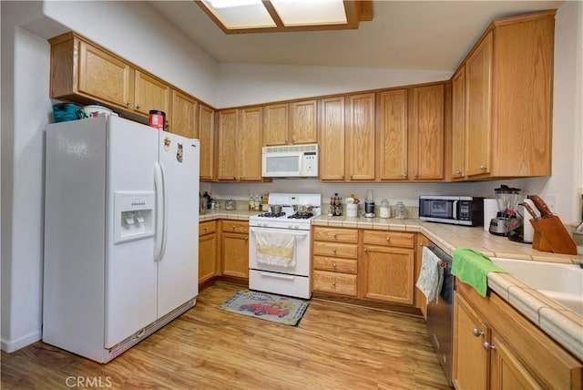 9024 Cascada Rd, Atascadero, CA 93422 - kitchen with stainless steel appliances, tile counters, vaulted ceiling, and light wood-style floors