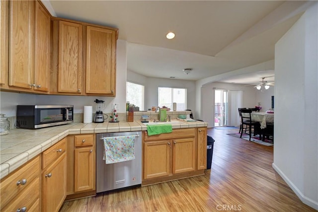 9024 Cascada Rd, Atascadero, CA 93422 - kitchen with stainless steel appliances, a sink, a peninsula, light wood-type flooring, and tile countertops