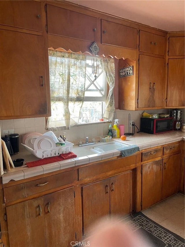 1017 Avenida De Pio Pico, Placentia, CA 92870 - kitchen with black microwave, backsplash, brown cabinets, tile countertops, and a sink
