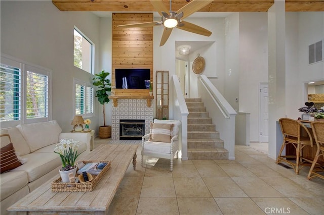 6456 Twinberry Cir, Avila Beach, CA 93424 - tiled living room with a high ceiling, a large fireplace, healthy amount of natural light, ceiling fan, and stairs