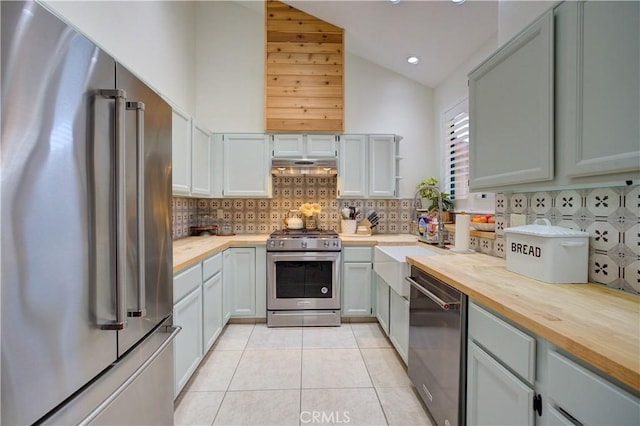 6456 Twinberry Cir, Avila Beach, CA 93424 - kitchen featuring stainless steel appliances, wooden counters, light tile patterned floors, tasteful backsplash, and high vaulted ceiling