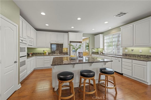 26520 Thackery Ln, Stevenson Ranch, CA 91381 - kitchen featuring white appliances, a center island, light wood-style floors, white cabinets, and recessed lighting