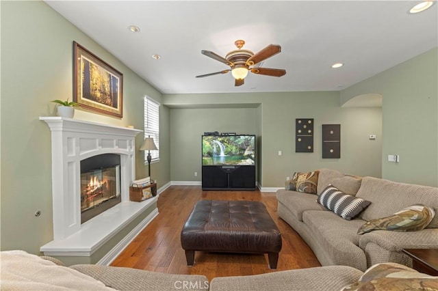 26520 Thackery Ln, Stevenson Ranch, CA 91381 - living area featuring arched walkways, wood finished floors, a ceiling fan, recessed lighting, and a glass covered fireplace