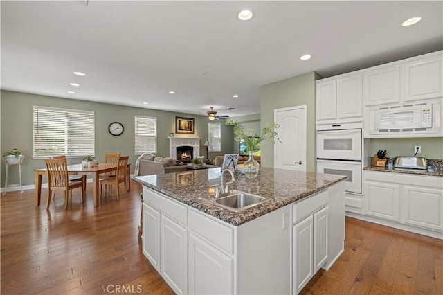 26520 Thackery Ln, Stevenson Ranch, CA 91381 - kitchen with white appliances, a lit fireplace, recessed lighting, ceiling fan, and a kitchen island with sink