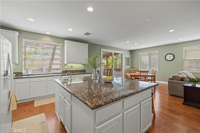 26520 Thackery Ln, Stevenson Ranch, CA 91381 - kitchen with an island with sink, recessed lighting, white cabinets, wood finished floors, and open floor plan